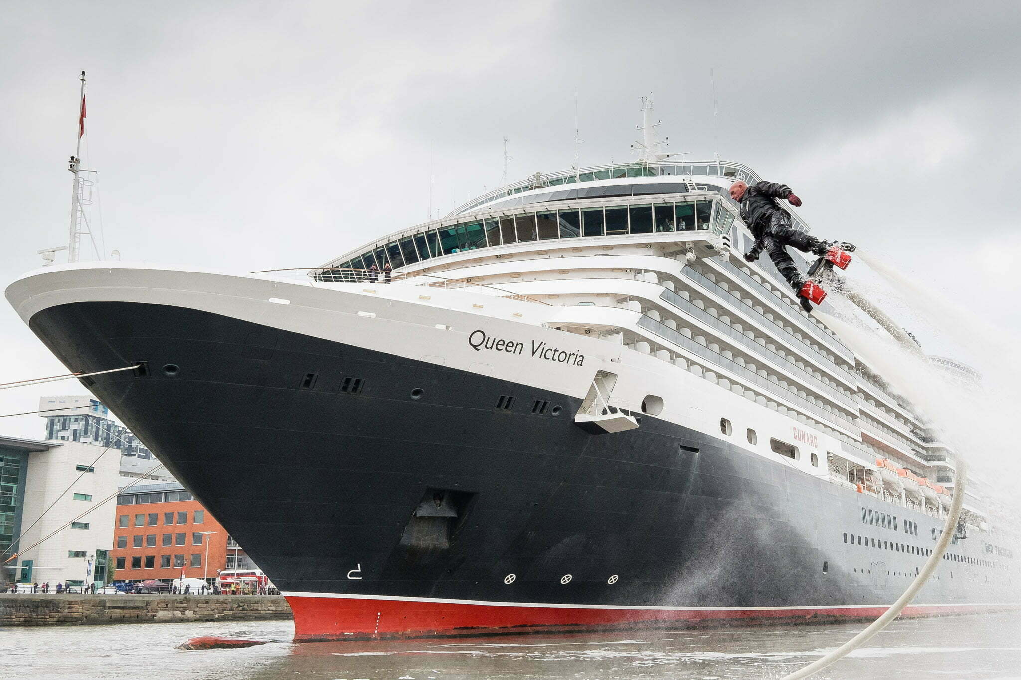 Cunard liner Queen Victoria arrives for the weekend in Liverpool, UK, 30th May, 2014. A man using a water based jet pack flies up to meet the captain of the Queen Victoria and welcome him to Liverpool.