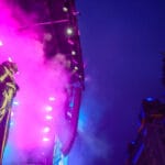 A member of Tvorchi looks up to the Liverbuilding lit up blue and yellow for the Ukrainin flag.