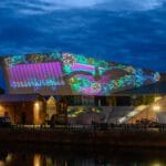 The Museum of Liverpool is lit up with 3D like projections. A Liver Bird flies out from the museum.