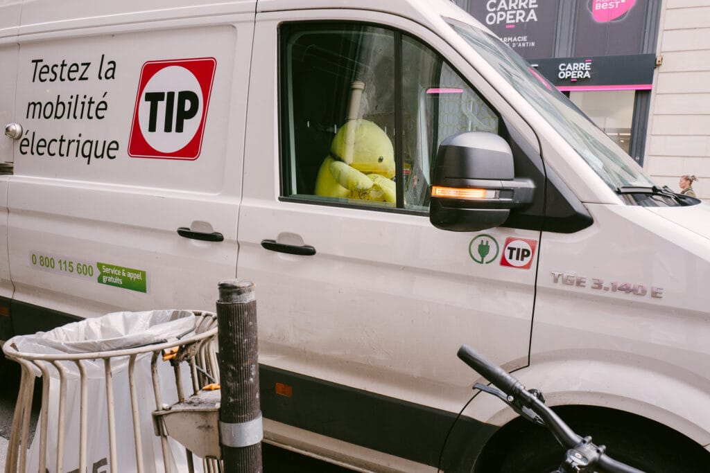 A yellow teddybear appears to be driving a van.