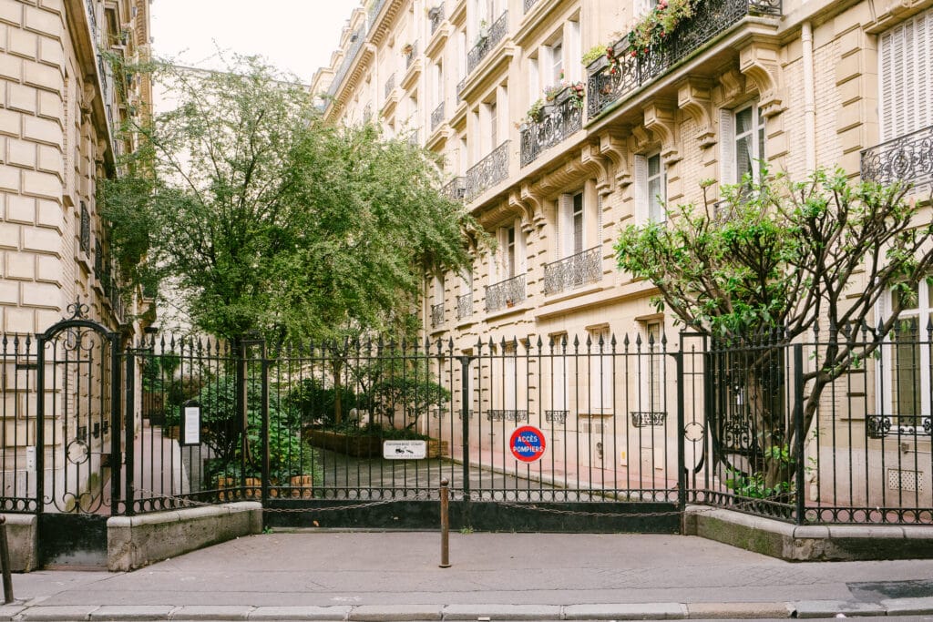 A gated community in Paris filled with trees and balconies.