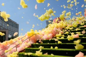 As colourful foam falls down large steps, it catches the wind and takes flight.