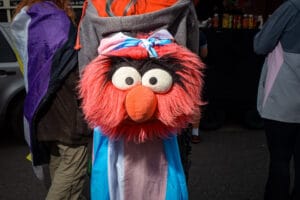 A person wearing a large stuffed animal head with a trans pride flag at Wirral Pride.