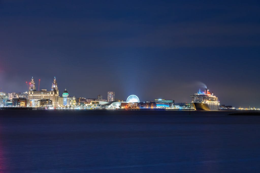 Night view of Liverpool waterfront featuring the Cunard cruise liner QM2