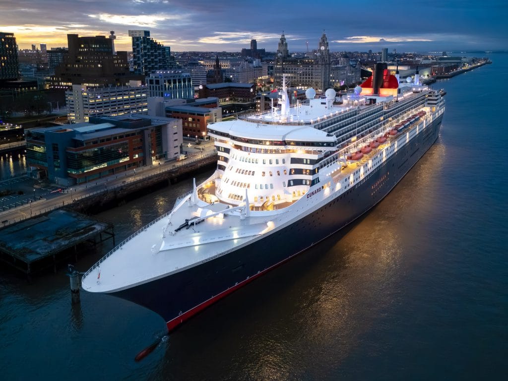 Aerial view of the Cunard cruise liner Queen Mary 2 docked in Liverpool, England, at sunrise.