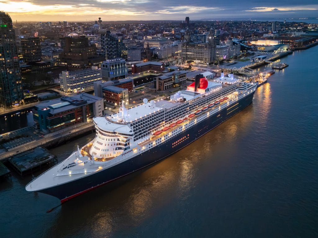 Aerial view of the Cunard cruise liner Queen Mary 2 docked in Liverpool, England, at sunrise.